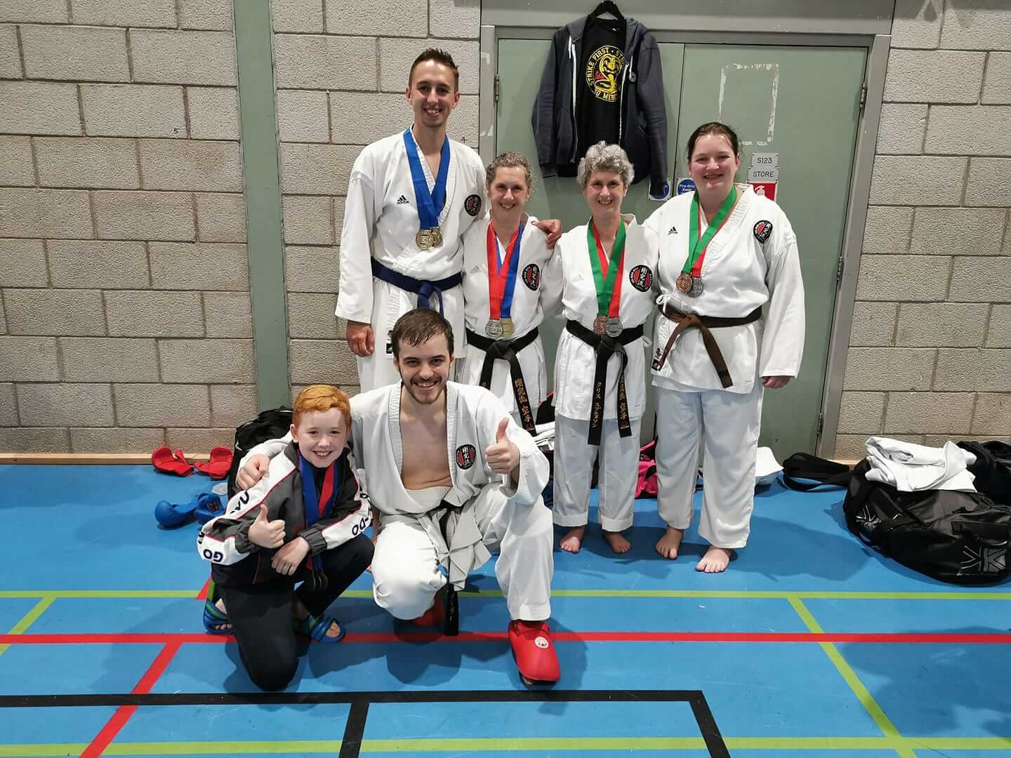 a group of black belt students posing for the camera