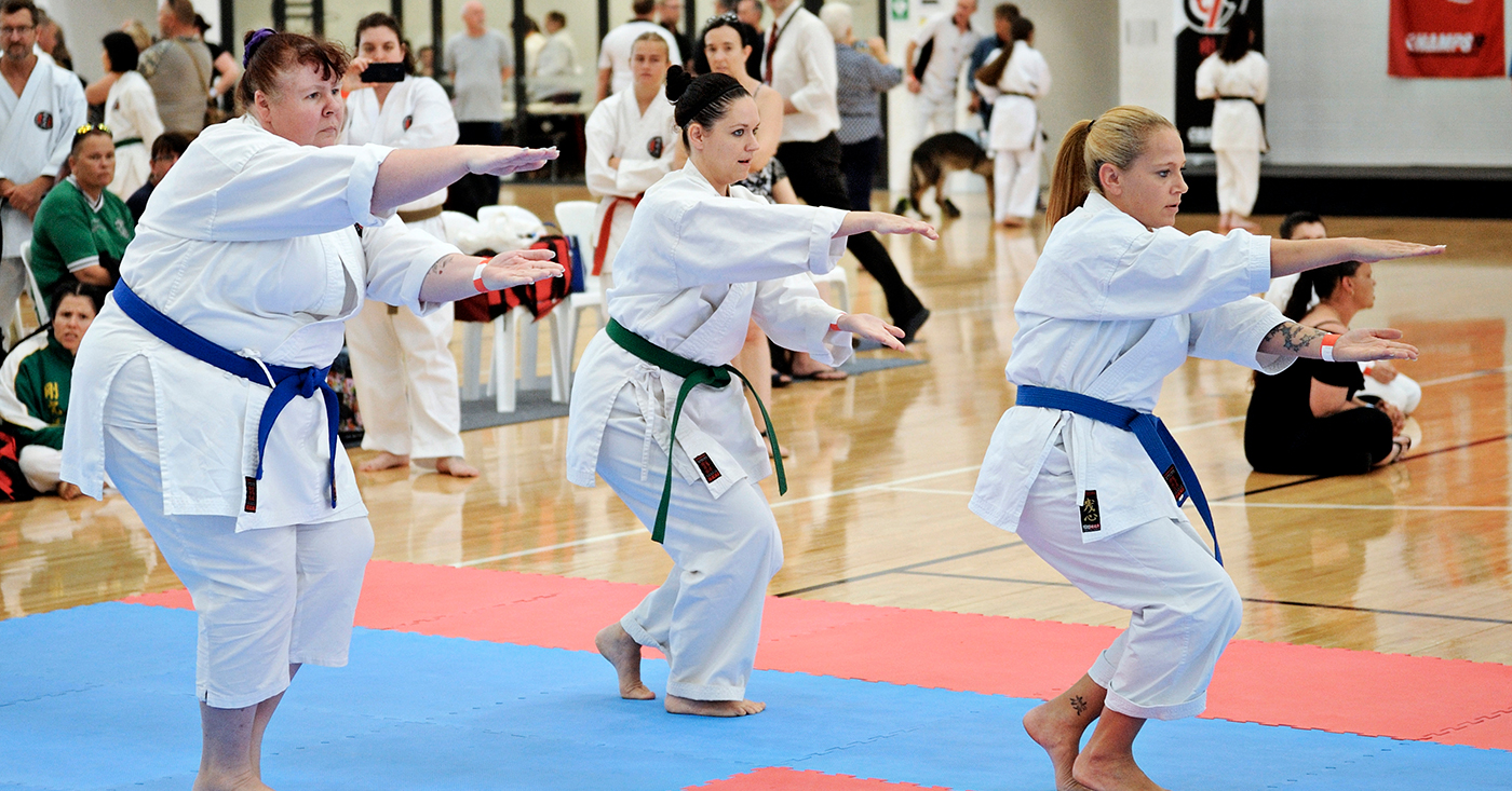 three people are performing stances